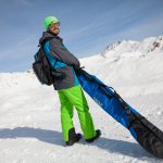 Mann mit Skitasche auf dem Berg