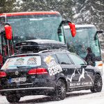 Auto mit Skibox im Schneefall von hinten